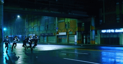 a group of people walking down a street at night