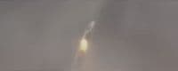 a rocket is flying through the air on a foggy day