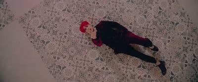 a person laying on a bed with a red hat
