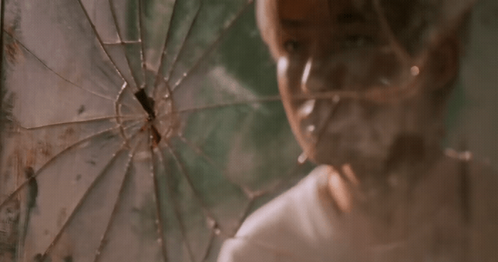 a man holding a broken umbrella in front of a mirror