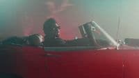 a man sitting in a red convertible car