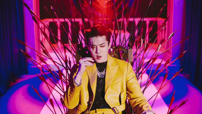 a woman in a yellow suit sitting in a chair