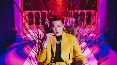 a woman in a yellow suit sitting in a chair