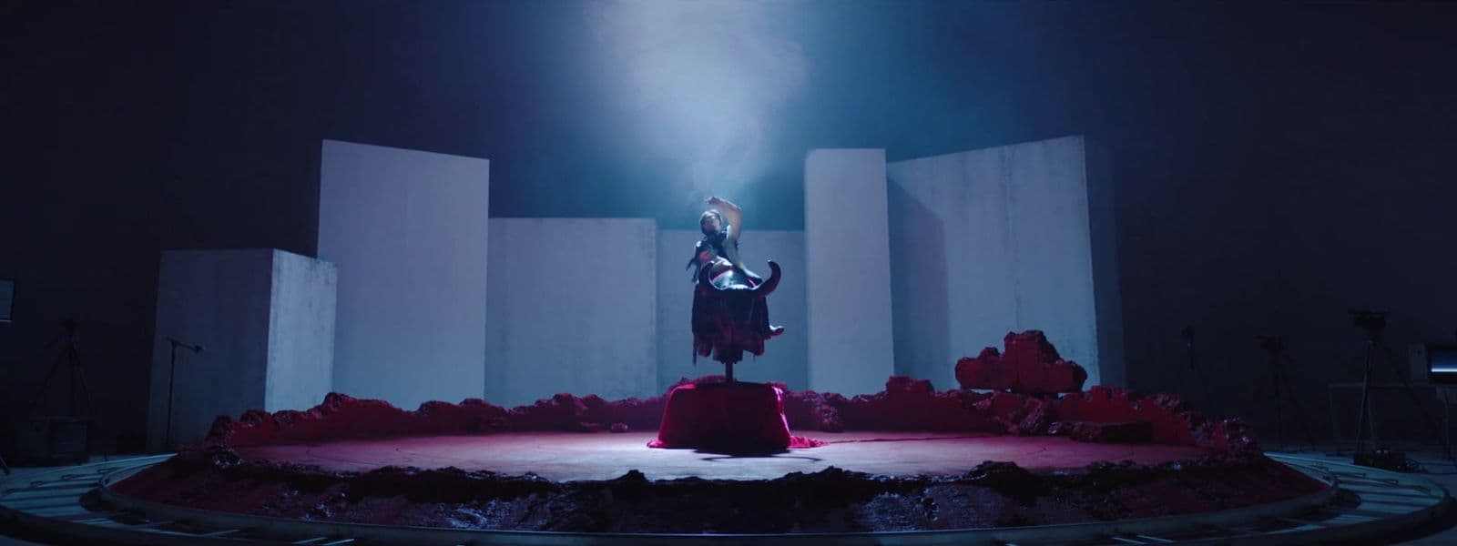 a woman standing on top of a stage in a dark room