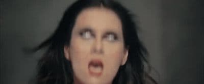 a woman making a face with her hair blowing in the wind