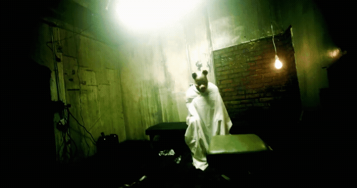 a man in a white robe standing in a dark room