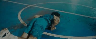 a man laying on top of a blue basketball court