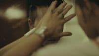 a man holding his hands up to his face