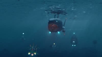 a submarine floating in the ocean with lights on