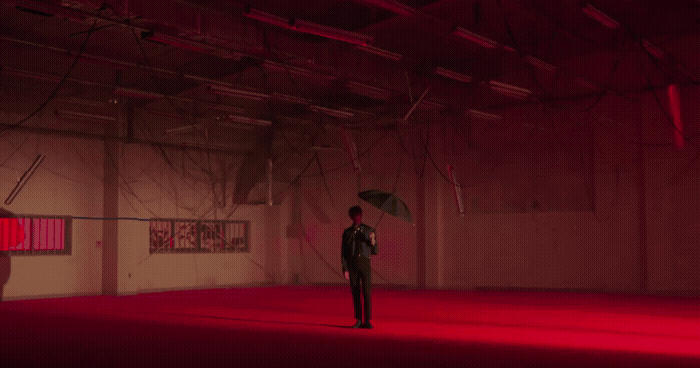 a man standing in a room holding an umbrella