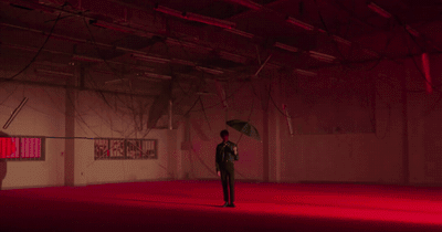 a man standing in a room holding an umbrella