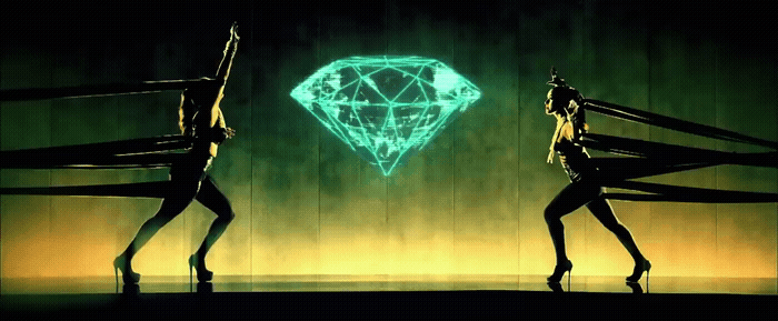 a couple of women standing next to each other in front of a neon diamond