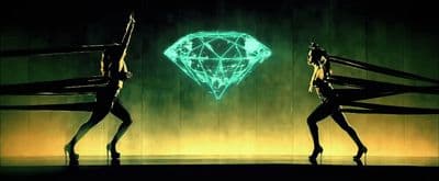 a couple of women standing next to each other in front of a neon diamond