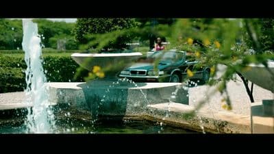 a car is parked in front of a fountain