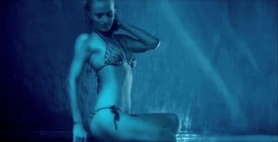 a woman in a bikini sitting in a shower