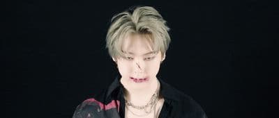 a male with a black shirt and a necklace