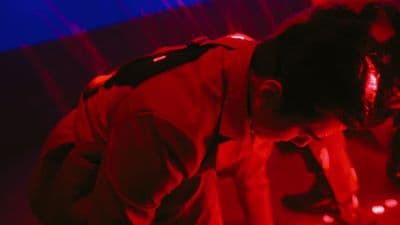a man in a red and blue light bending over