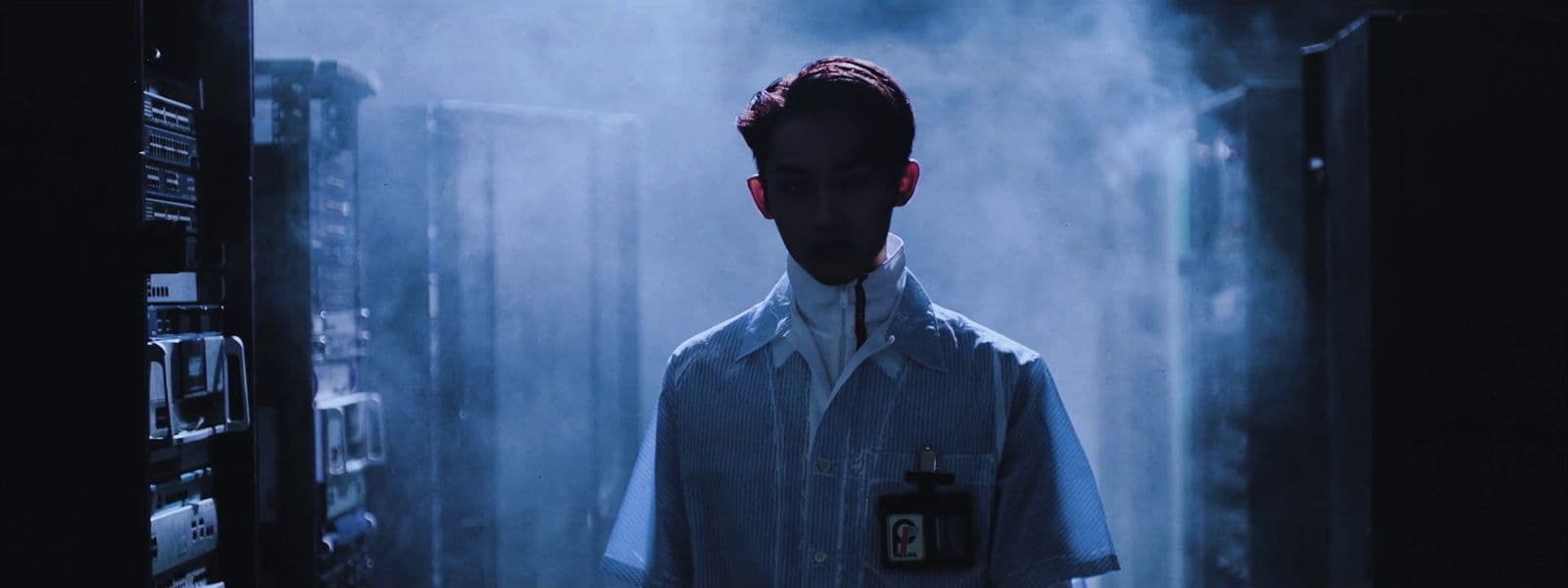a man in a lab coat standing in a dark room