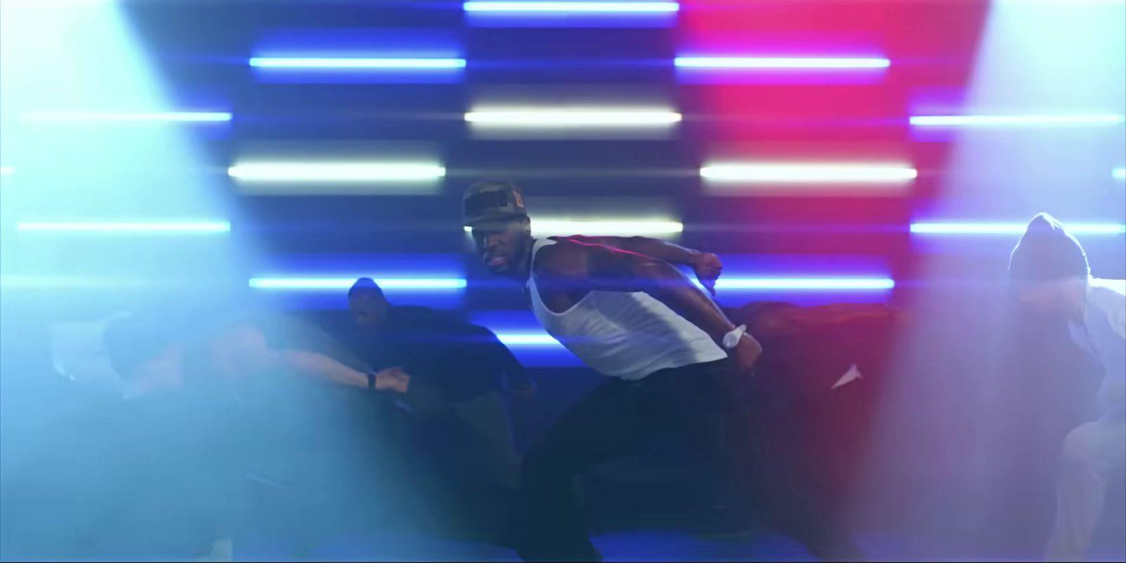 a man in a white shirt is dancing on stage