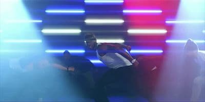 a man in a white shirt is dancing on stage