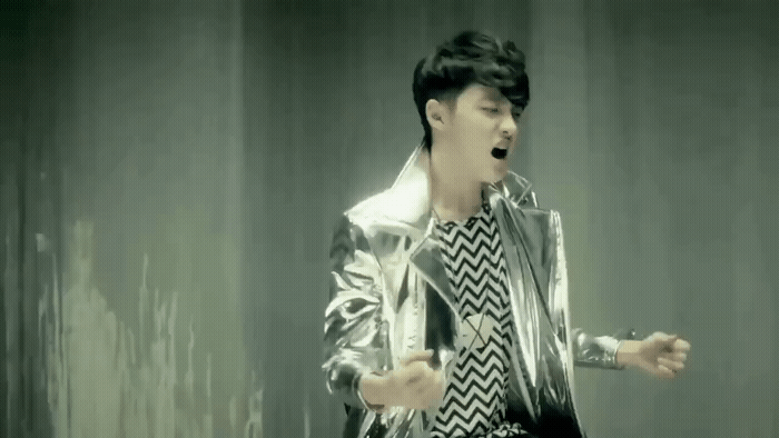 a male in a silver jacket and a black and white shirt