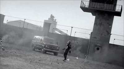 a woman standing in front of a truck on a dirt road