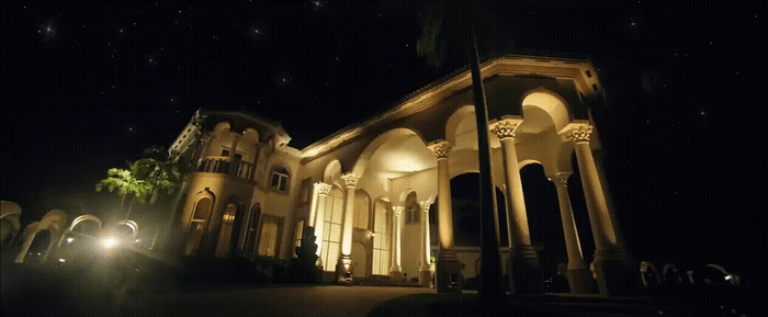a large building lit up at night with stars in the sky