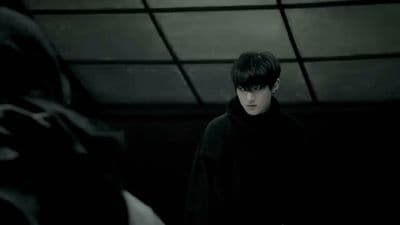 a man standing in a dark room next to a bat