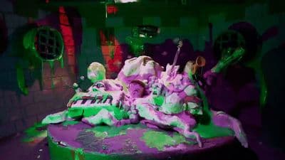 a green and purple cake sitting on top of a table