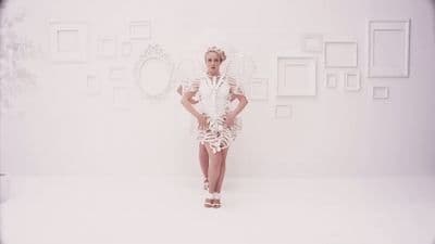 a woman in a white dress standing in front of a white wall