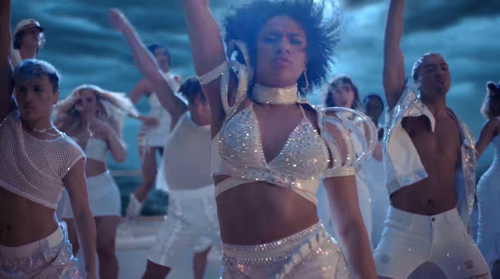 a group of women in white outfits dancing