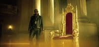 a man standing in front of a golden throne