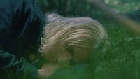 a young boy laying down in the grass