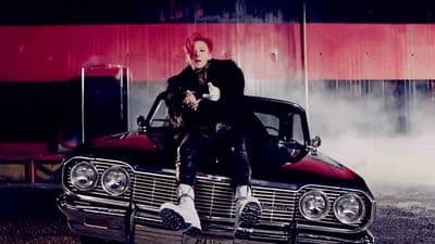 a man sitting on the hood of a car