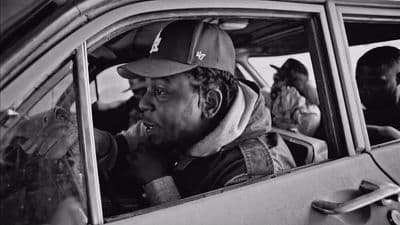 a black and white photo of a man in a car