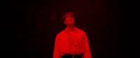 a man standing in the dark with his eyes closed