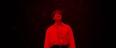 a man standing in the dark with his eyes closed