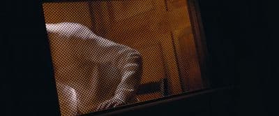 a person standing in front of a screen door