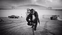 a man riding a skateboard across a parking lot