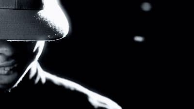 a black and white photo of a person wearing a hat