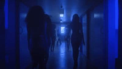 a group of people walking down a hallway in the dark