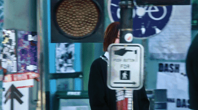 a woman standing next to a traffic light
