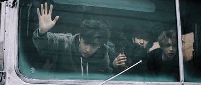 a group of young men riding on the back of a bus