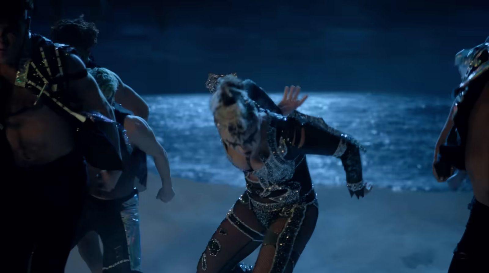 a group of people in costume dancing on a beach
