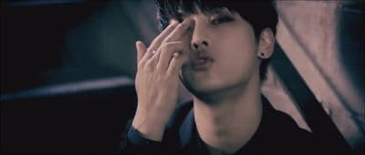 a person holding their hand up to their face