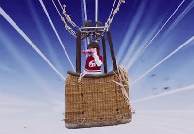 a man sitting on top of a hot air balloon