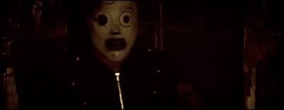 a person wearing a mask in a dark room