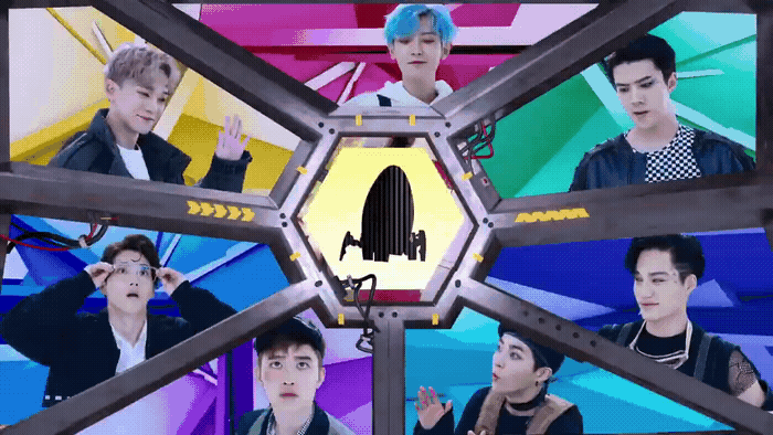 a group of young men standing in front of a tv screen