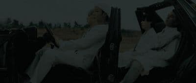 two men sitting in the back of a car