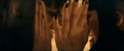 a woman's hands with black nail polish on them